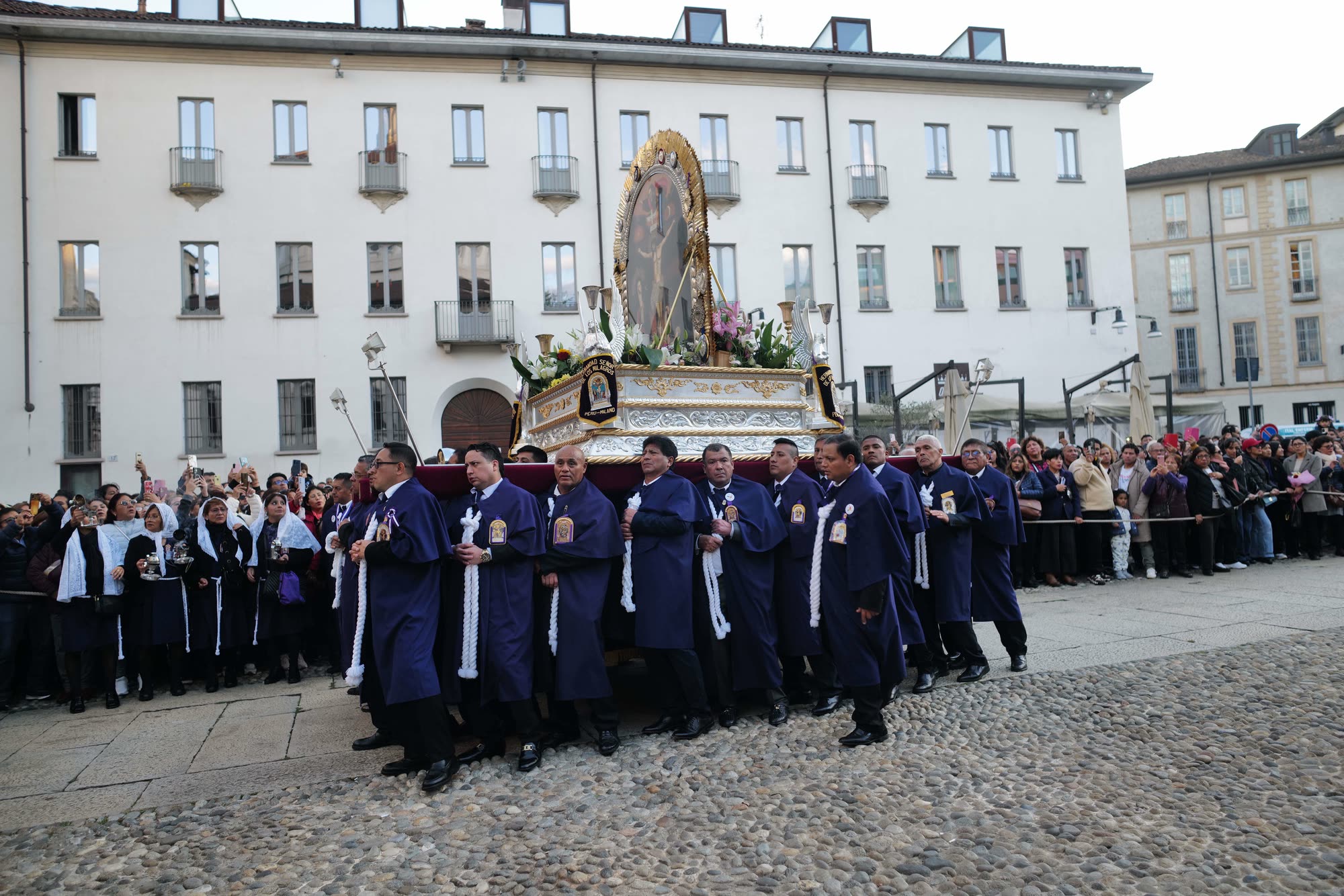 L'anda del Señor de los Milagros attraversa una piazza di Milano, portata dai cargadores in abito viola