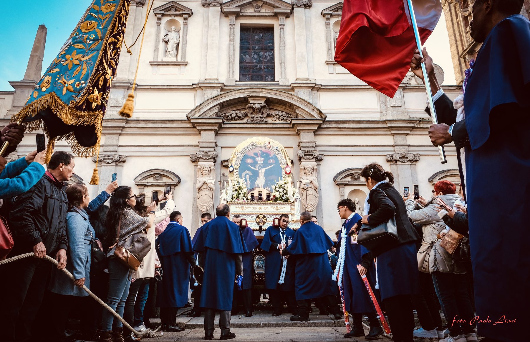 Processione con stendardi davanti a una chiesa milanese